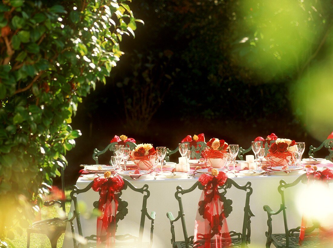 Gedeckter Tisch im Garten für ein romantisches Sommerfest