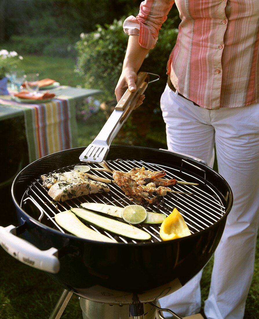 Frau beim Grillen im Garten