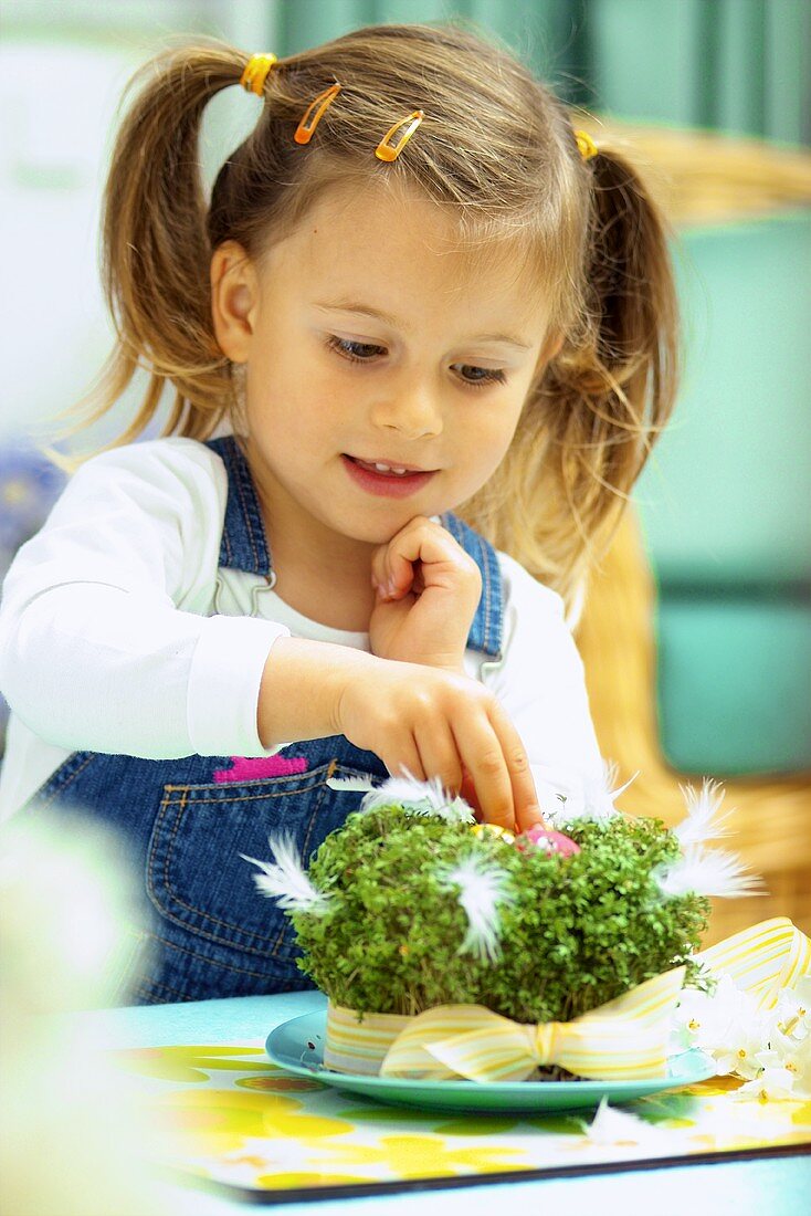 Small girl with cress Easter nest