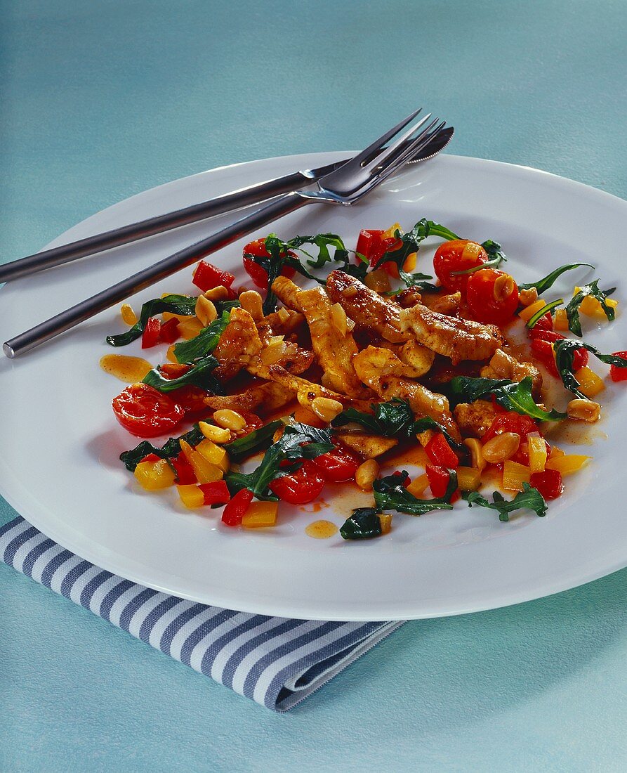 Strips of turkey breast with rocket, tomatoes and peanuts