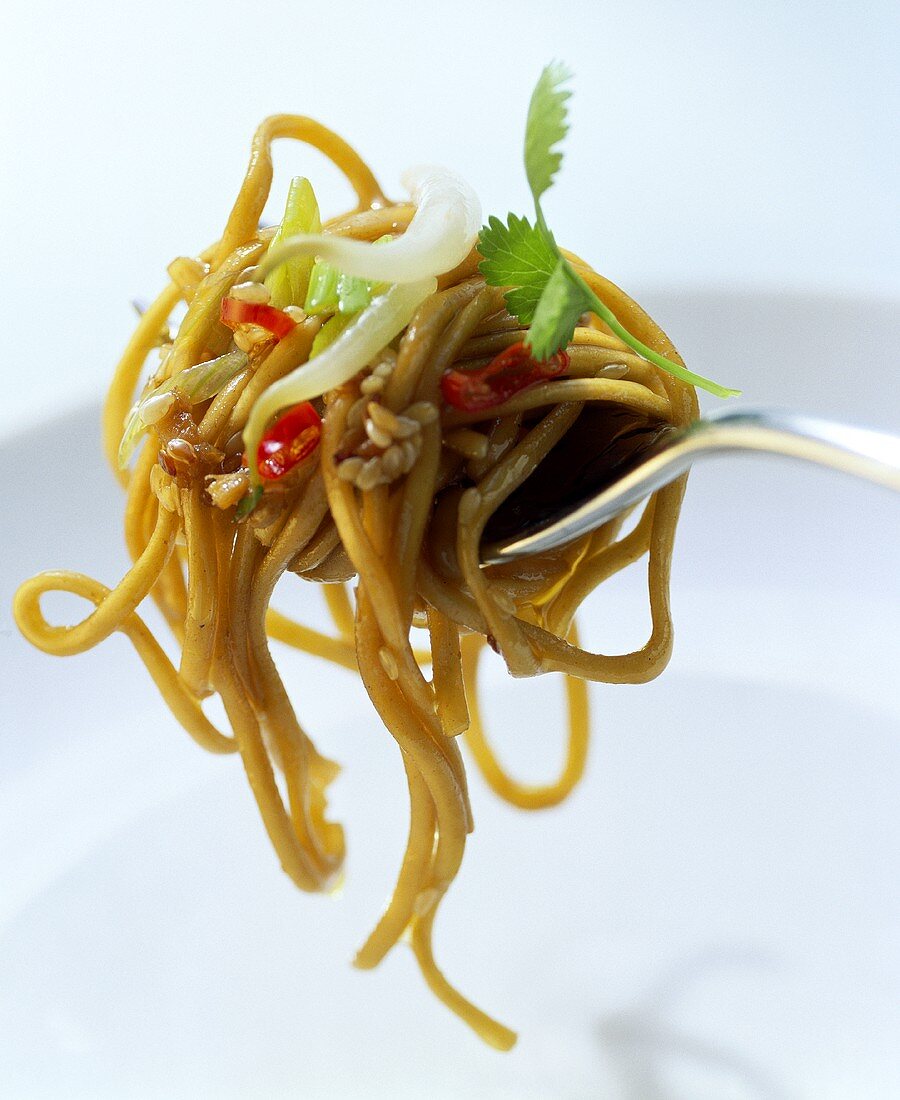 Egg noodles with chili and ginger sauce on fork