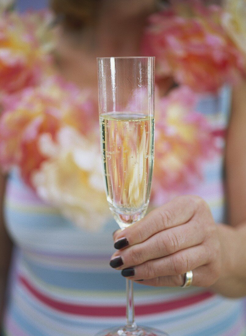 Woman in summer dress holding glass of champagne