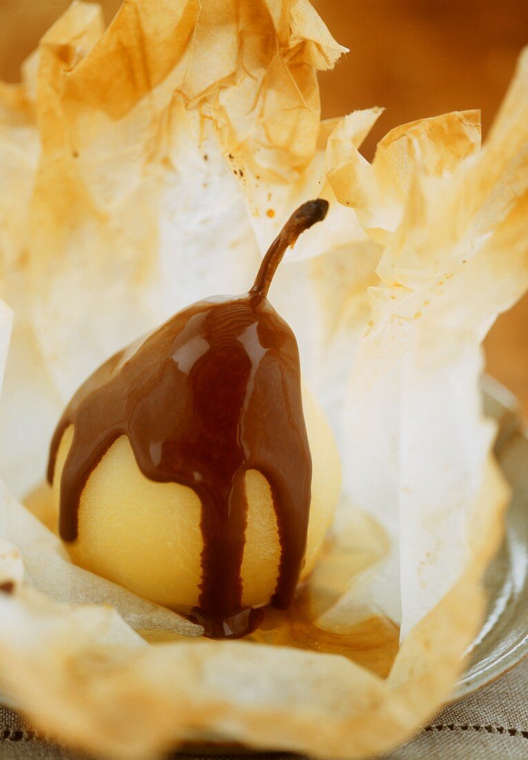 Poached pear with chocolate sauce in filo pastry