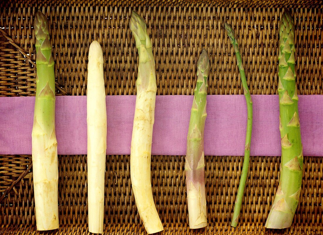 White and green asparagus spears on wicker tray