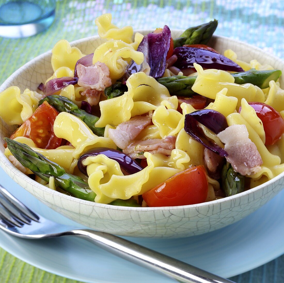 Pasta salad with bacon, green asparagus and tomatoes