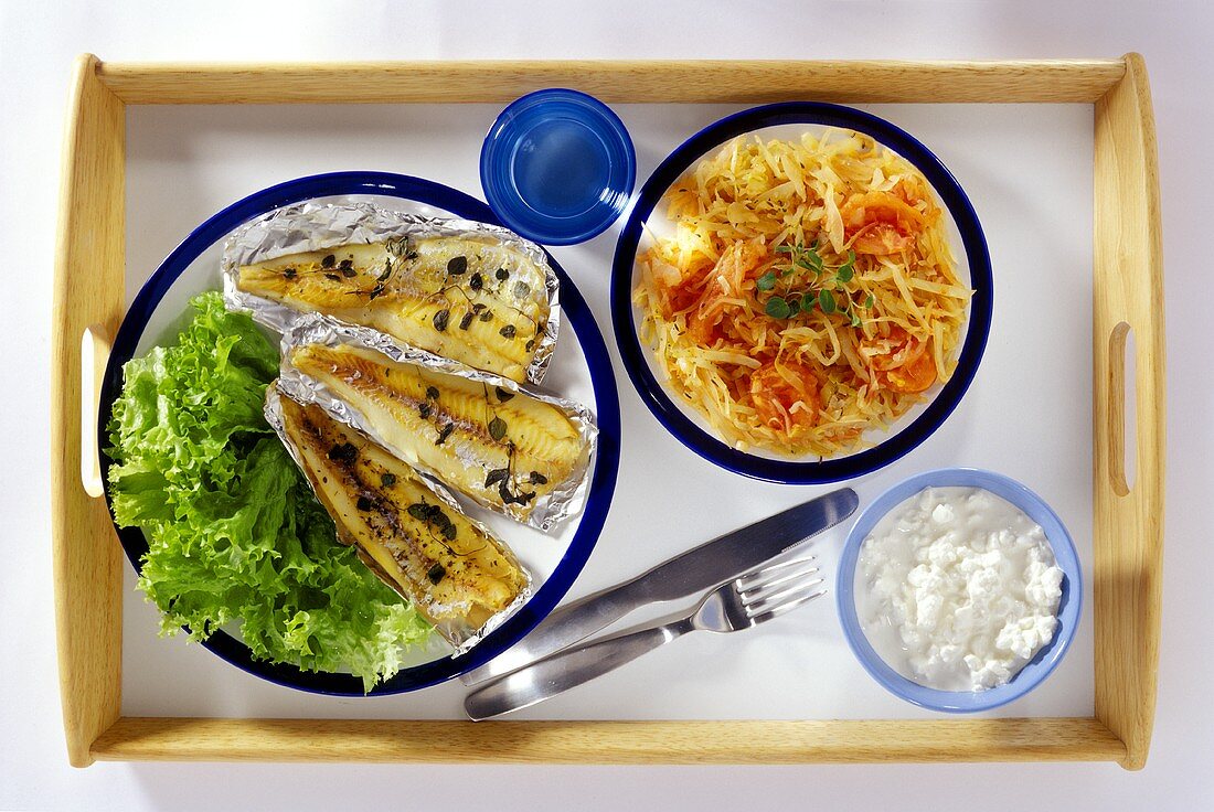 Fish fillets in foil, lettuce and cottage cheese on tray