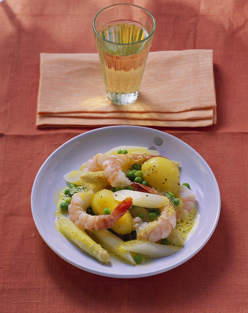 Shrimps with saffron whip and vegetables; glass of white wine