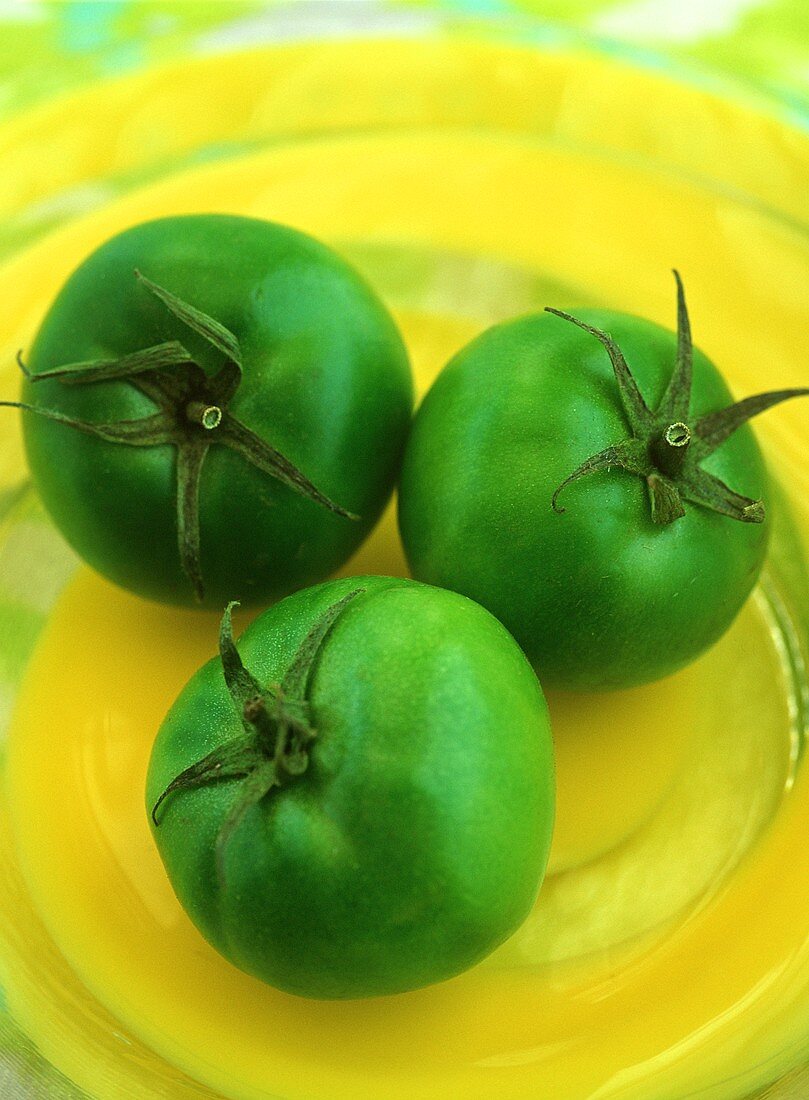 Green tomatoes on yellow plate