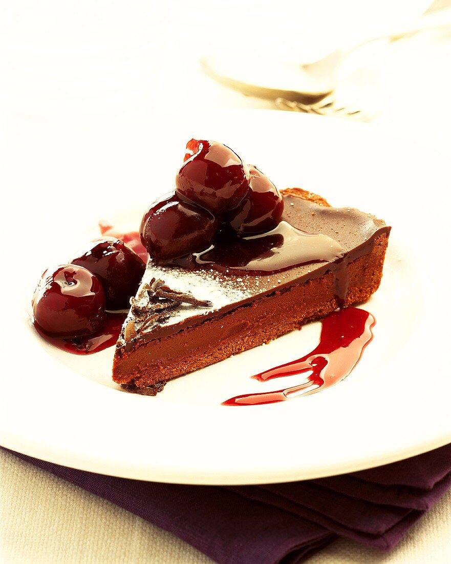 Piece of chocolate cake with cherries and cherry liqueur