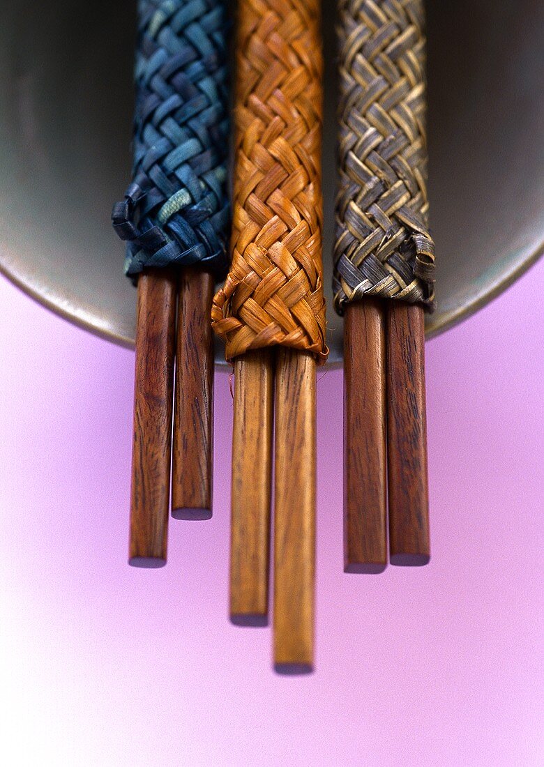 Three pairs of chopsticks on bowl