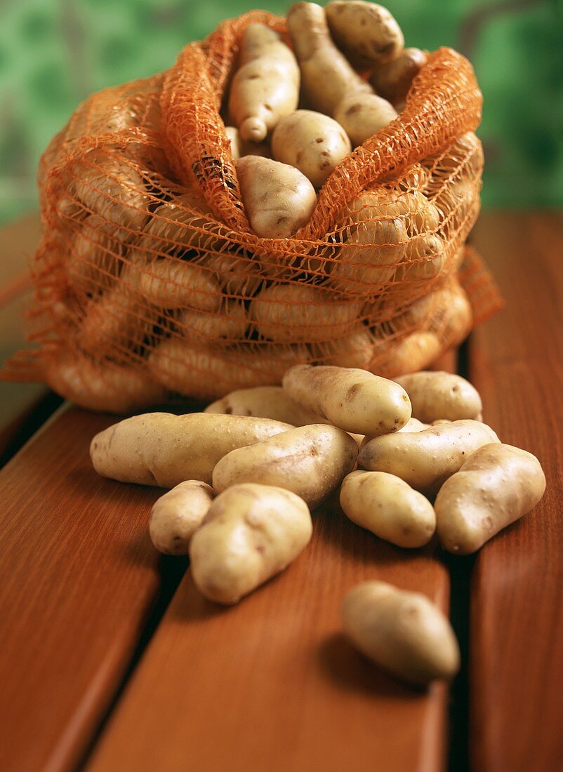 Kartoffeln im Sack auf Holztisch