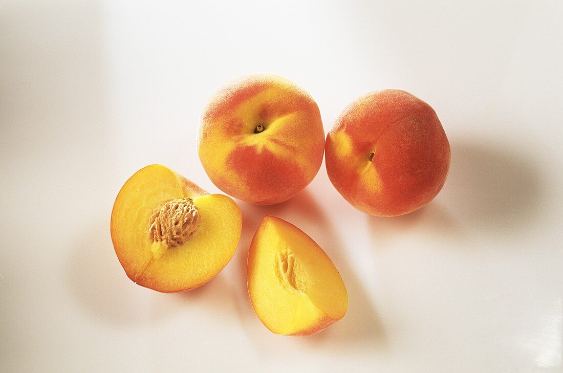 Whole and halved peaches