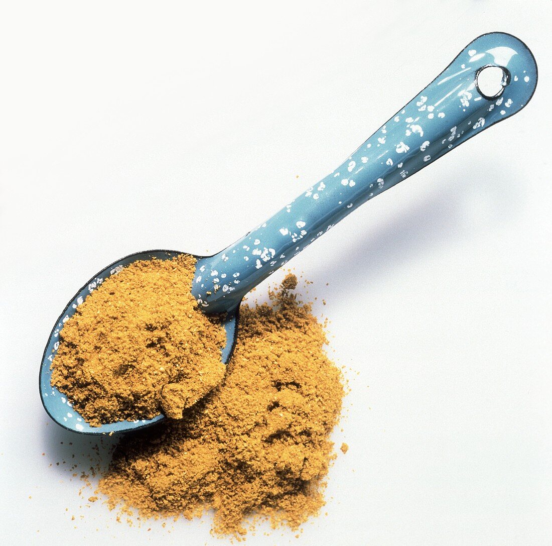 Curry powder on and beside spoon 