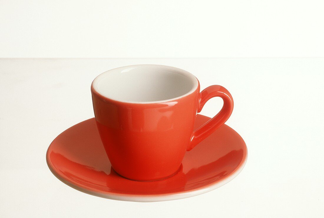 A red coffee cup with saucer