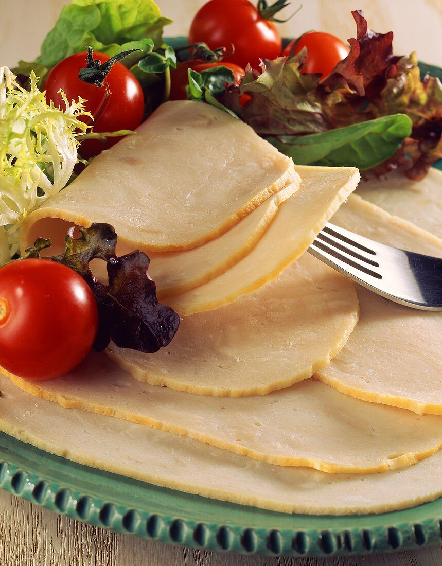 Sliced turkey breast with salad on plate
