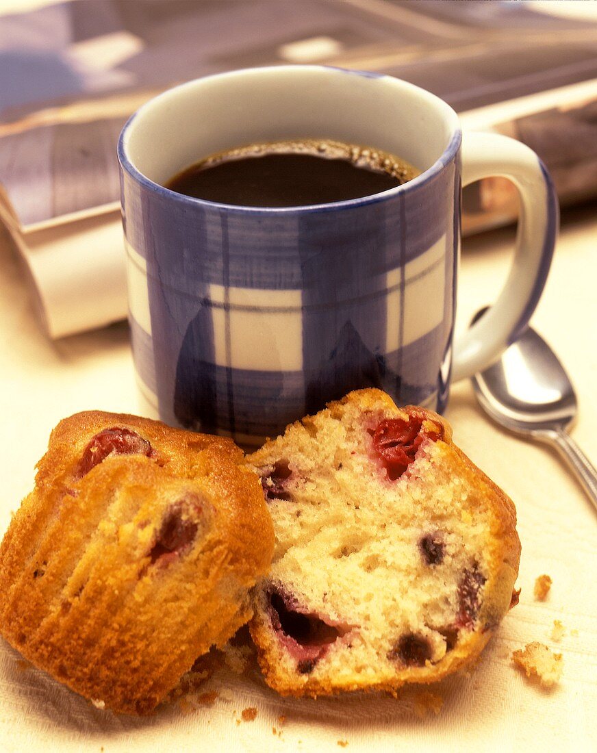 Eine Tasse Kaffee mit geteiltem Muffin