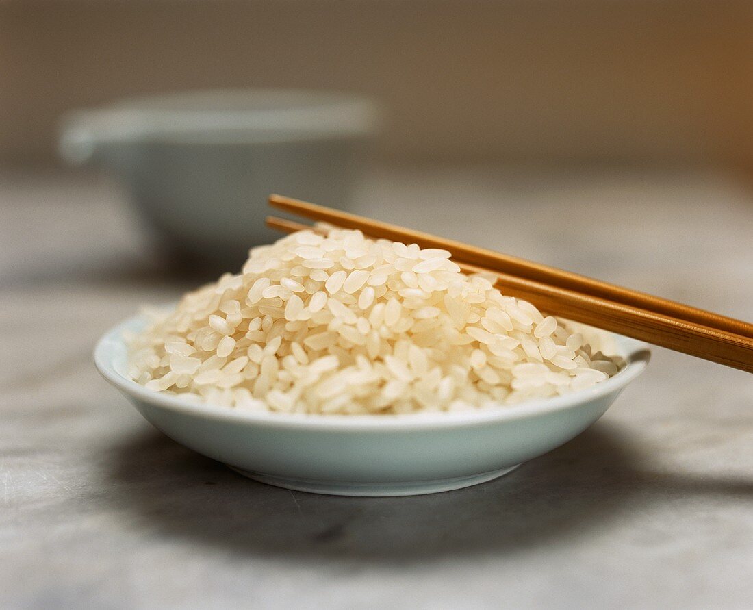 Sushi rice in a bowl with chopsticks