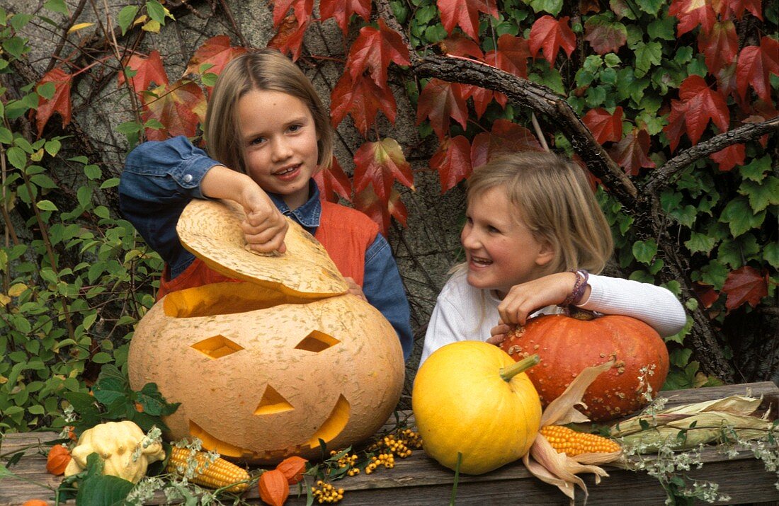 Zwei Mädchen mit einem geschnitzten Kürbis zu Halloween