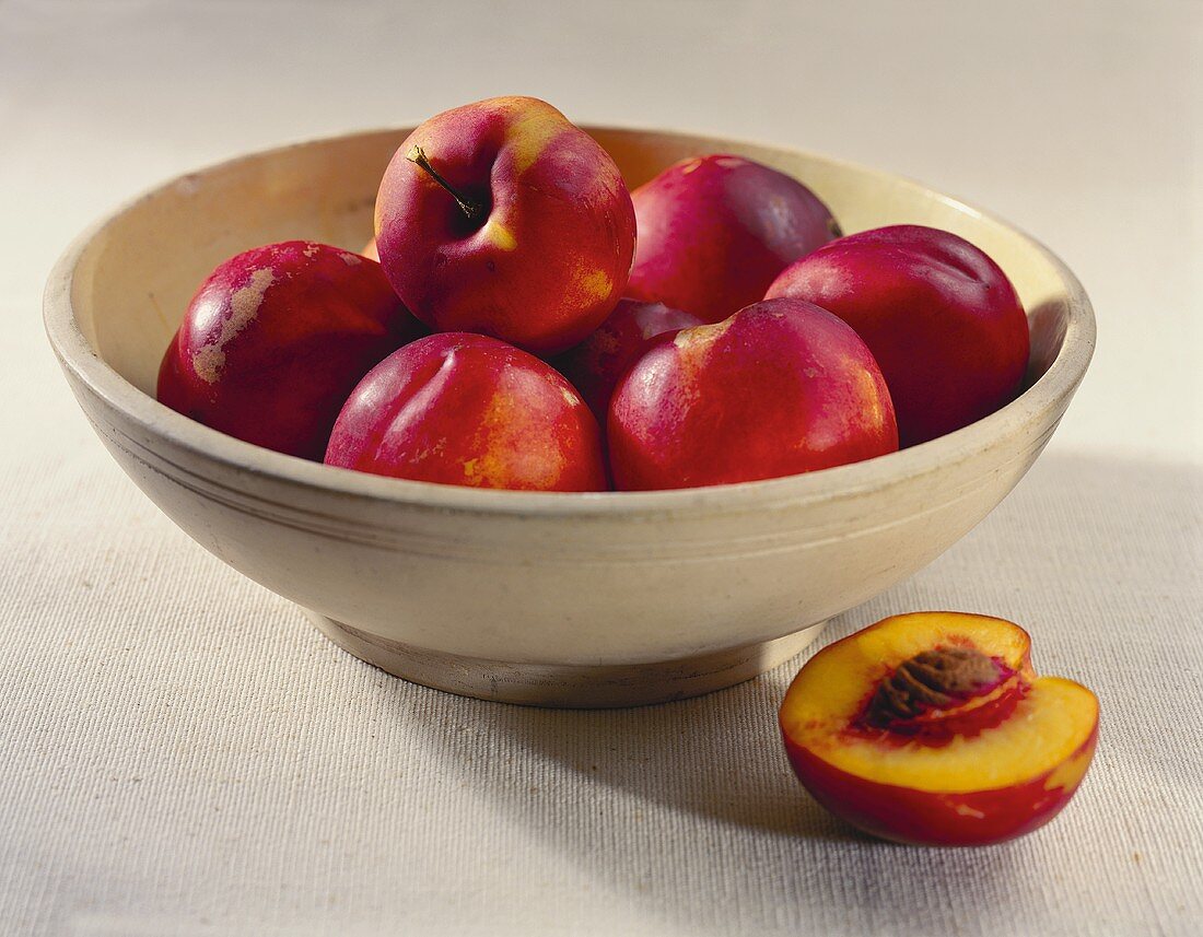 A Bowl of Nectarines; One Half Next to Bowl