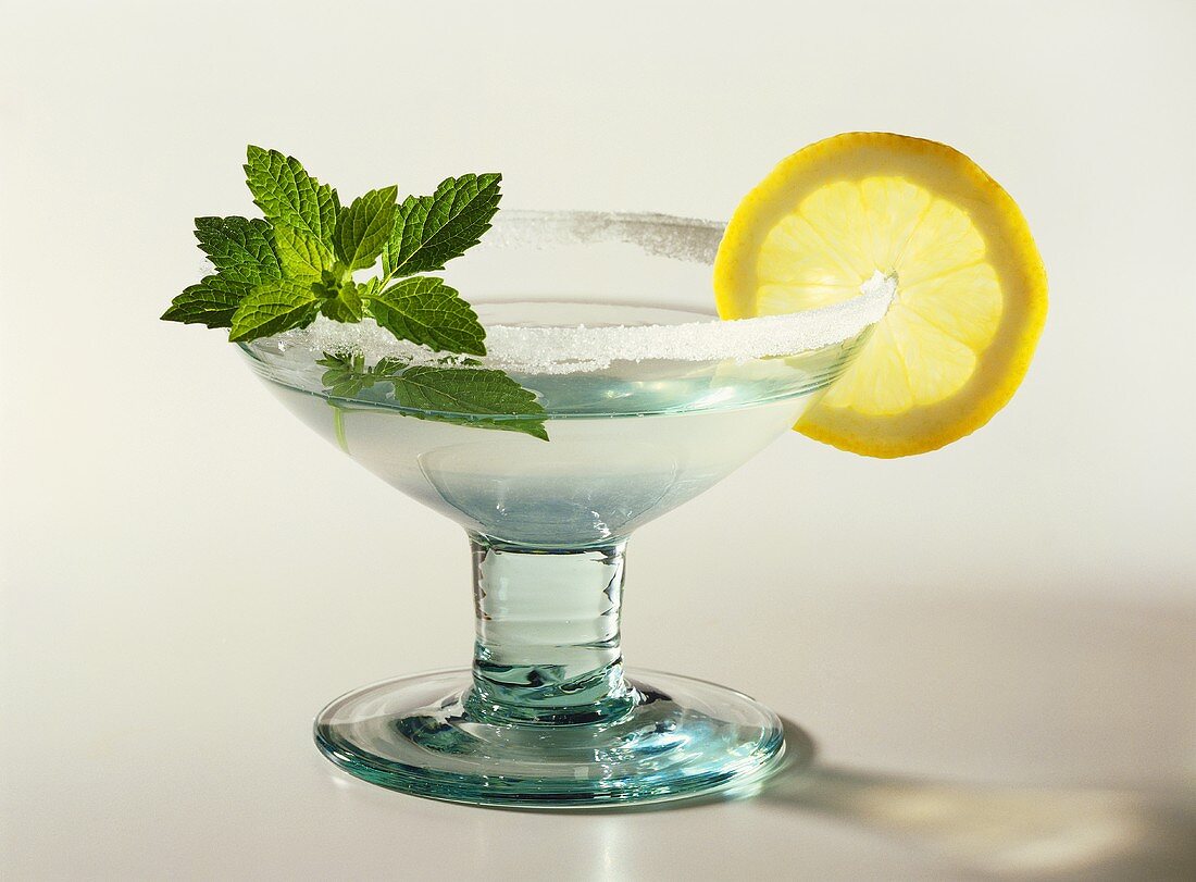 A glass of Margarita cocktail with mint leaves