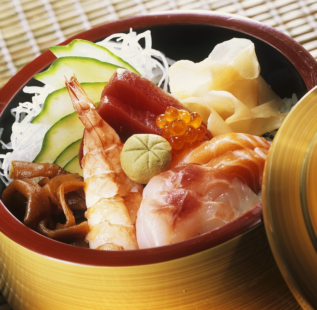 Chirashi-Sushi mit gemischtem Fisch im Bambuskörbchen