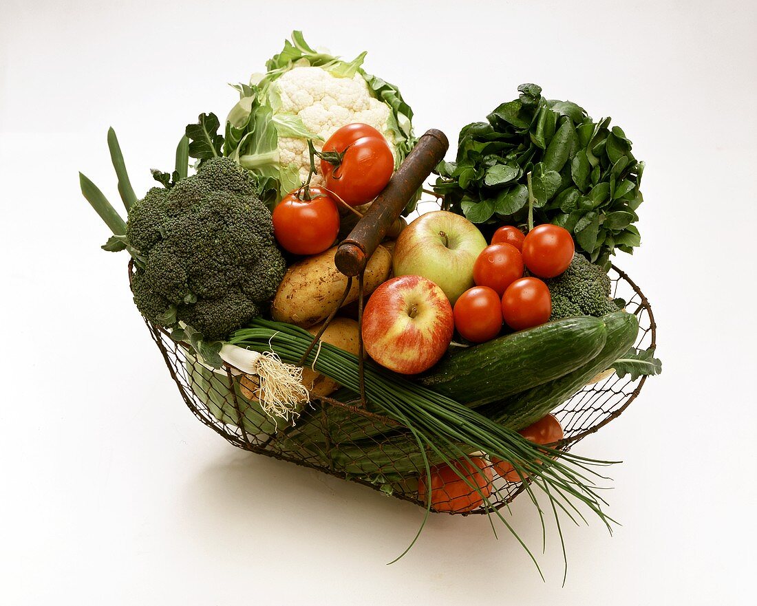 Fresh vegetables and apples in a wire basket