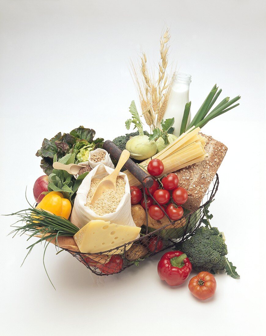 Various foodstuffs in and beside wire basket