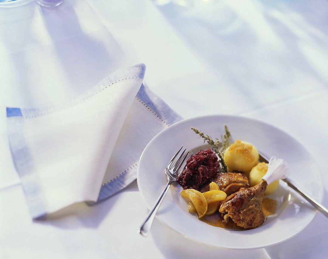 Duck leg with potato dumplings, red cabbage and apples