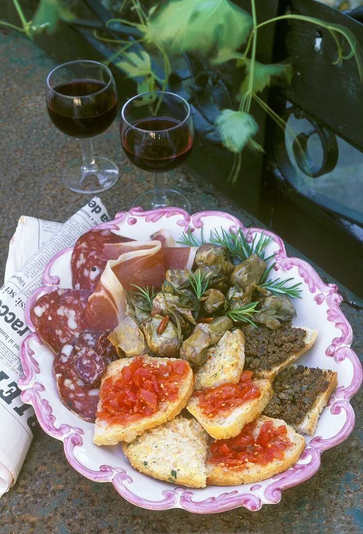 Plate of antipasti with bruschetta, crostini, sausage