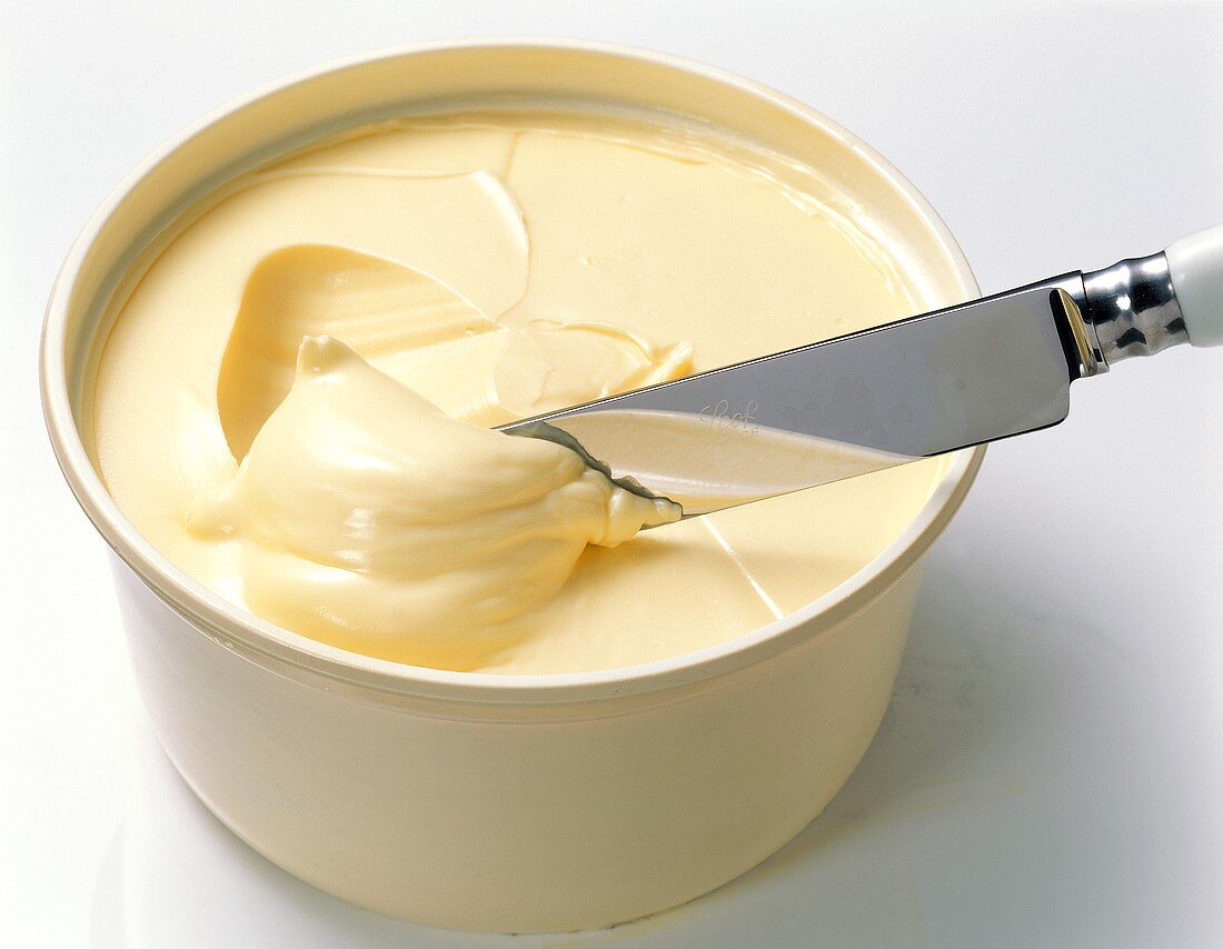 Ein Becher Margarine mit Messer