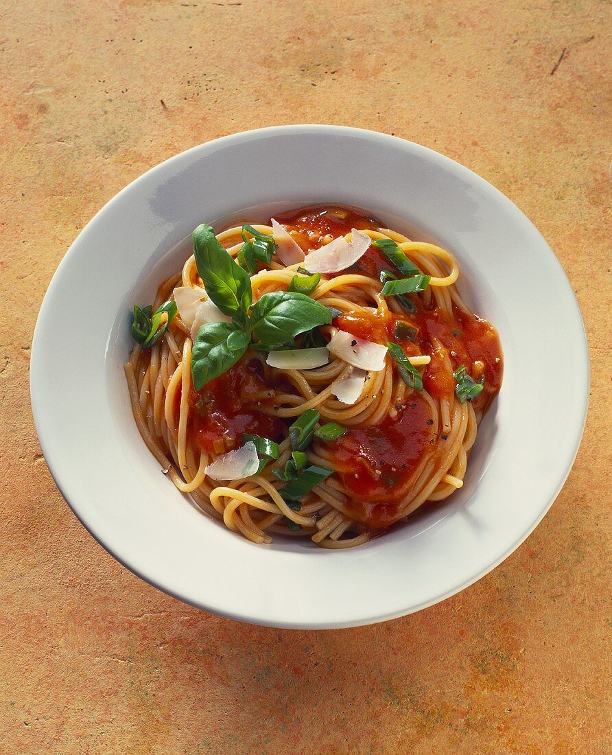 Spaghetti mit Tomatensauce, Parmesanspänen und Basilikum