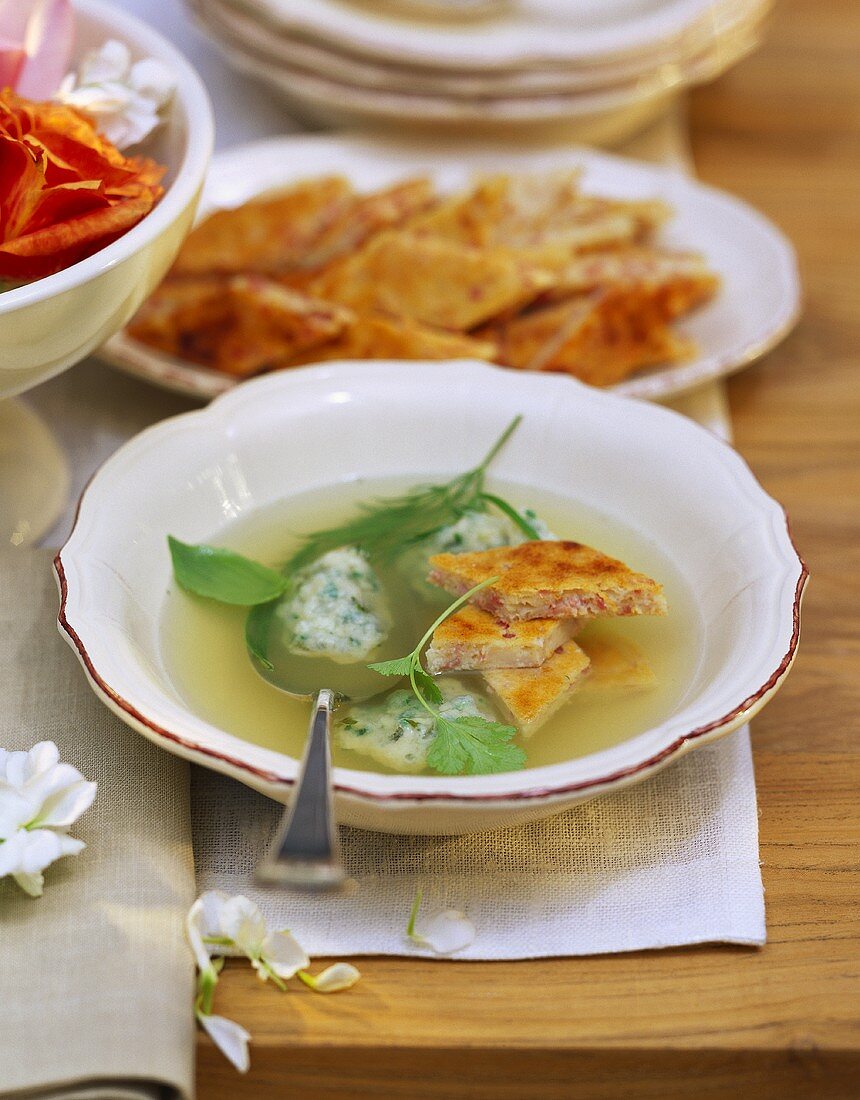 Green wedding soup with herb dumplings and ham dumplings