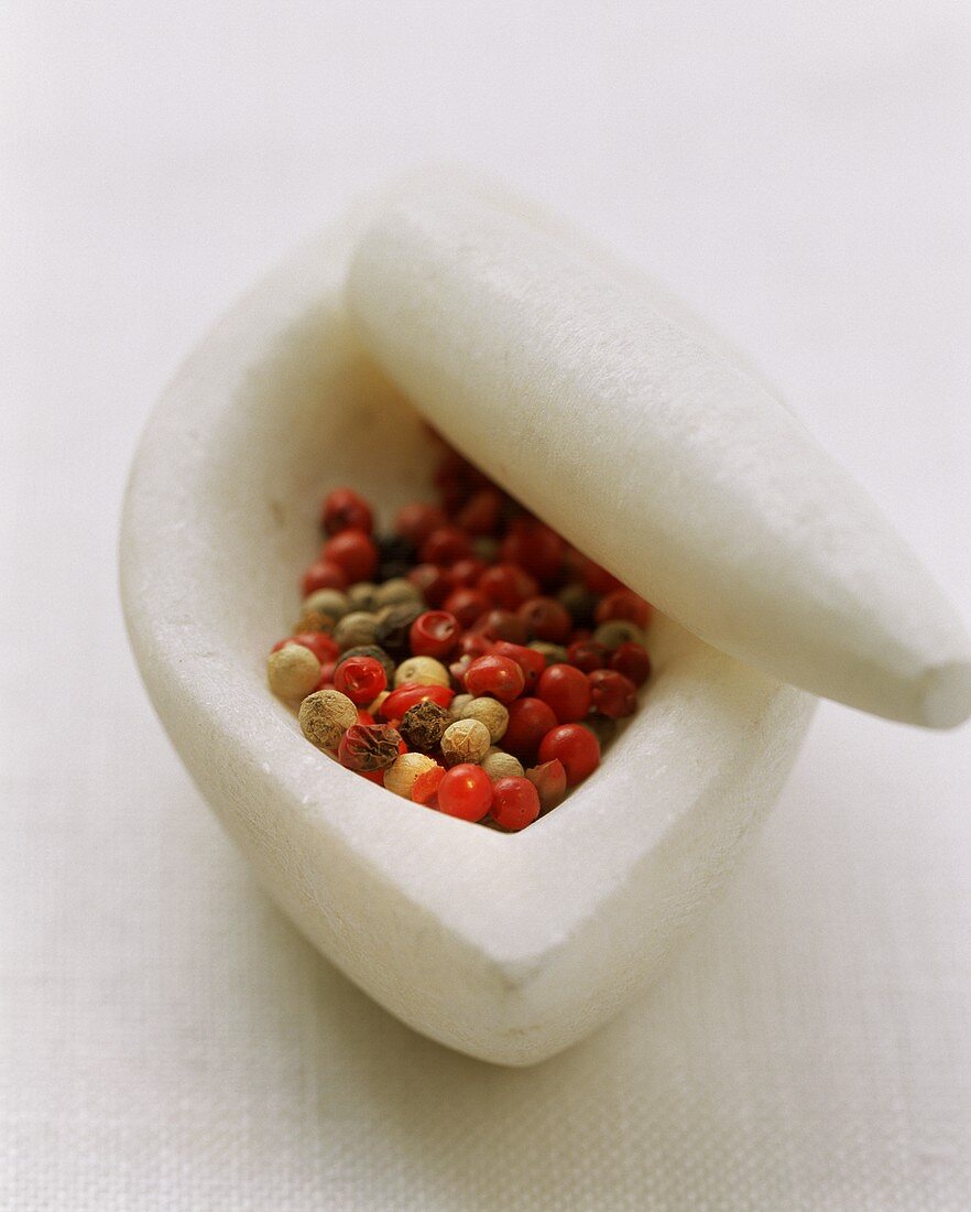 Coloured peppercorns in mortar