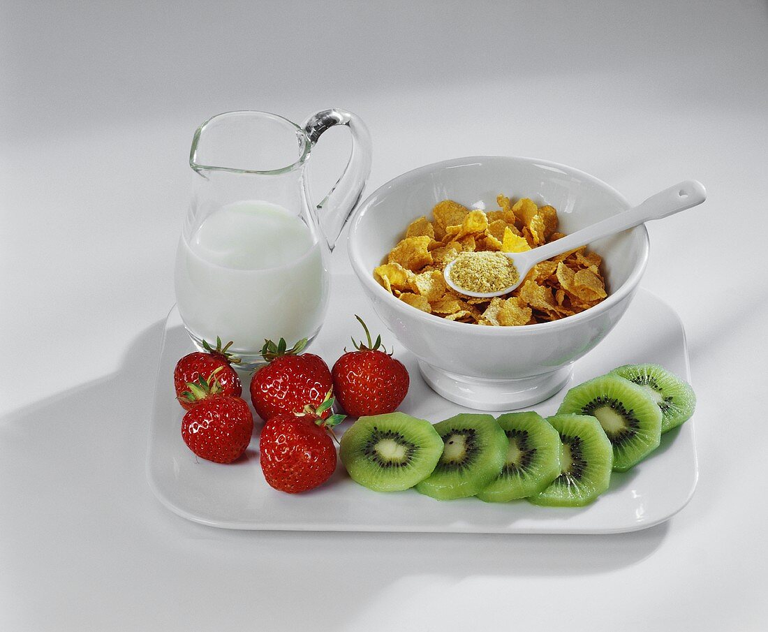 Cornflakes, Milch, frische Erdbeeren und Kiwis