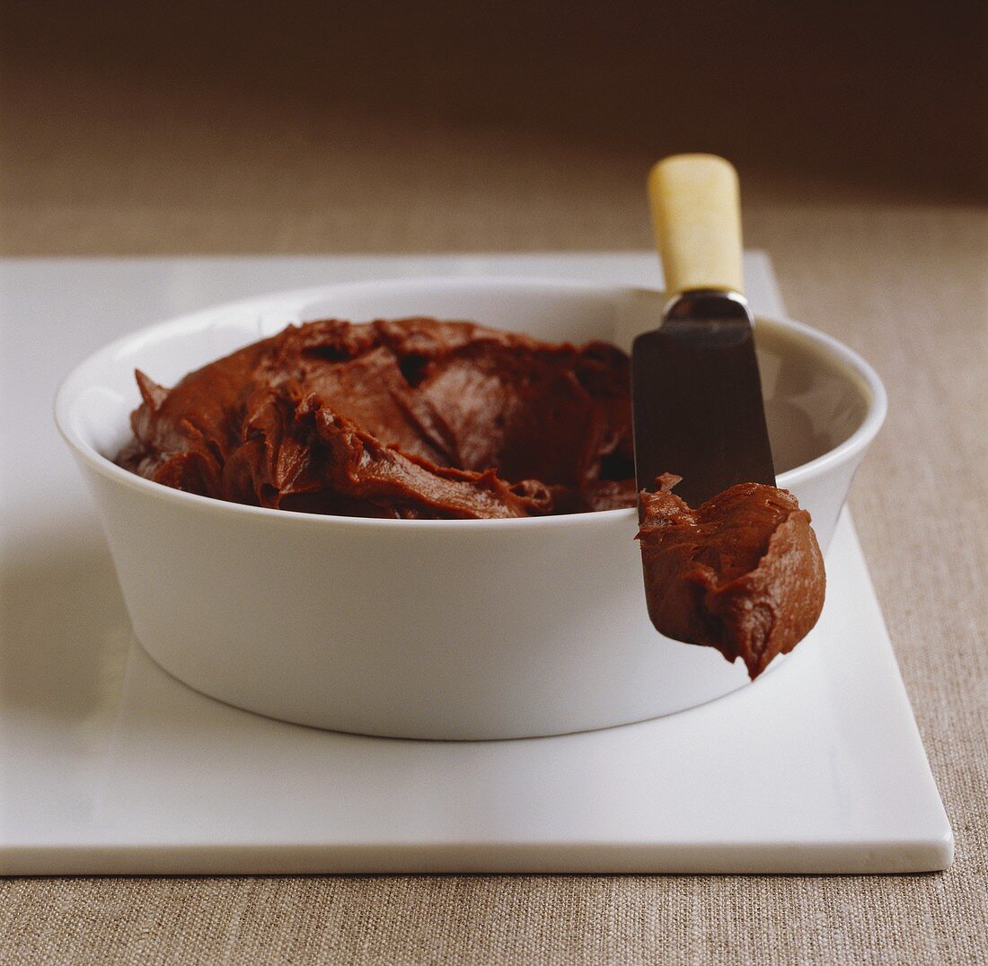 Chocolate hazelnut cream in bowl with knife