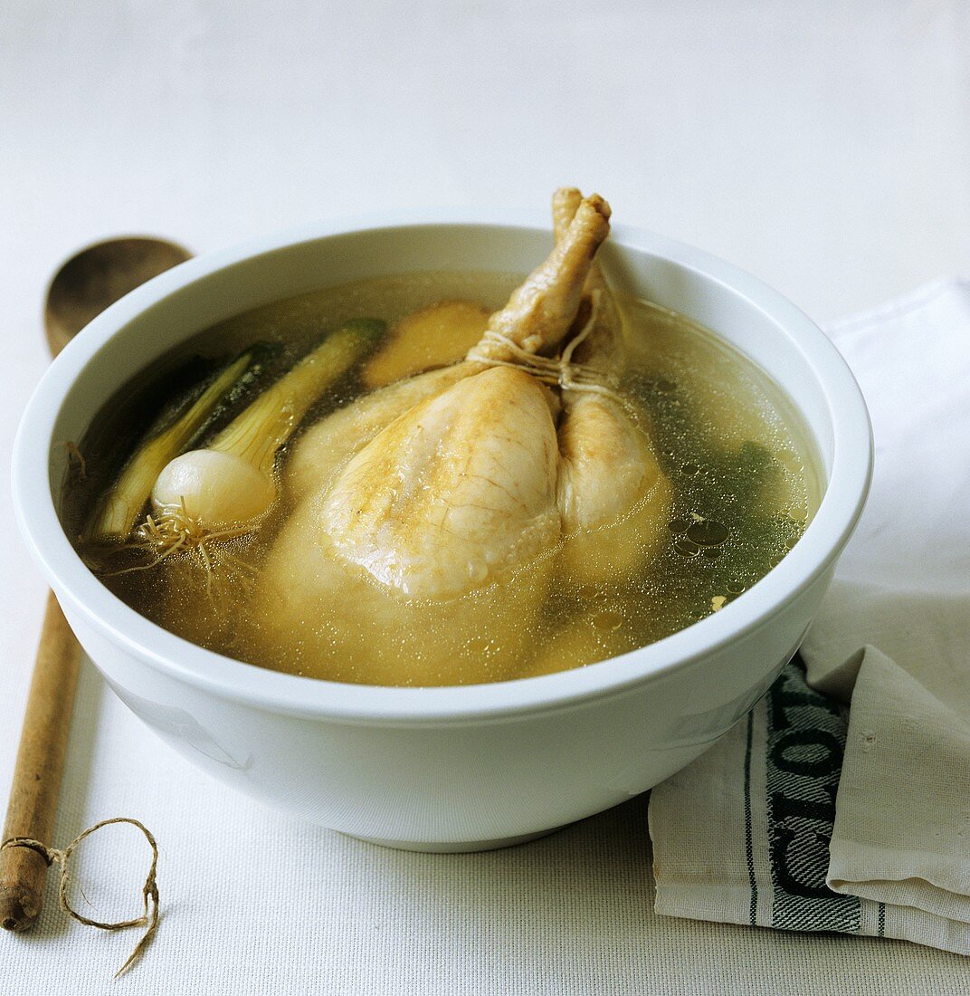 Hühnerbrühe zubereiten: Suppenhuhn in Schüssel