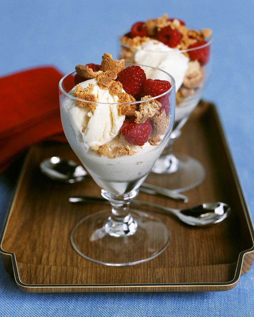 Vanilla ice cream and raspberries in sundae glasses 