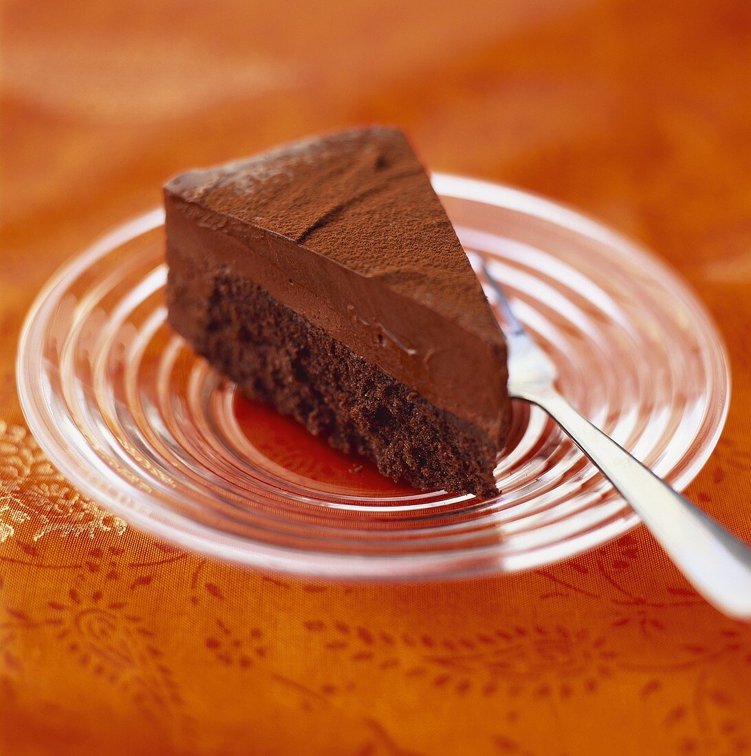 Piece of chocolate cream cake on glass plate