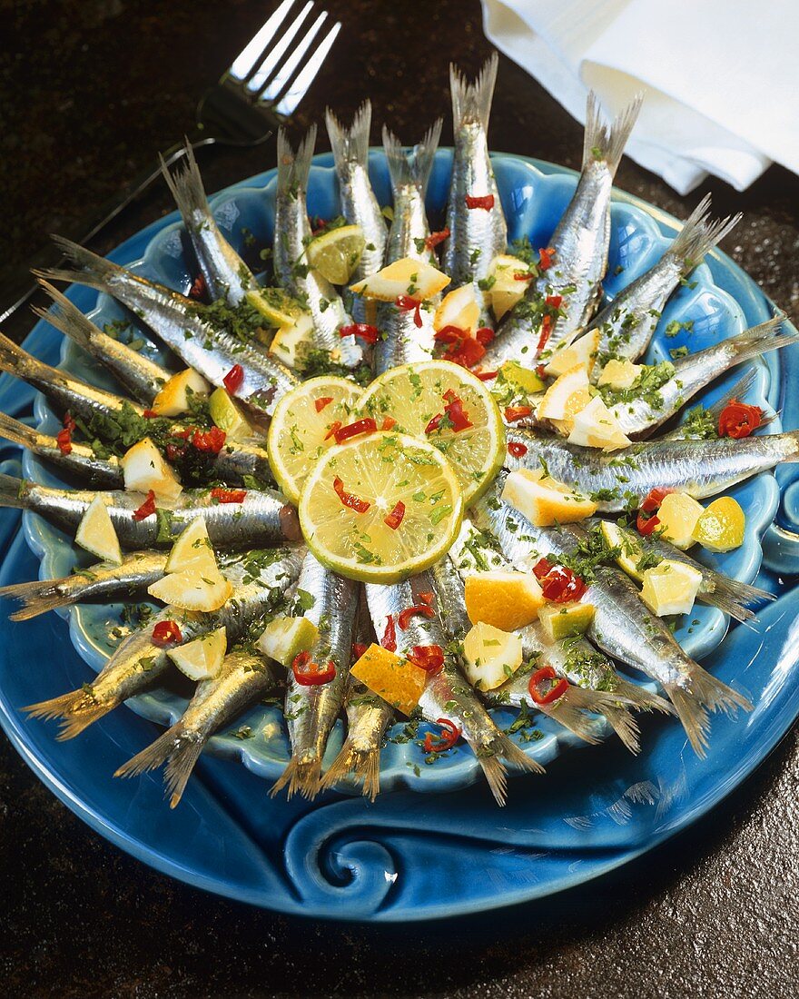 Marinated sardines with lemons, herbs and chili rings