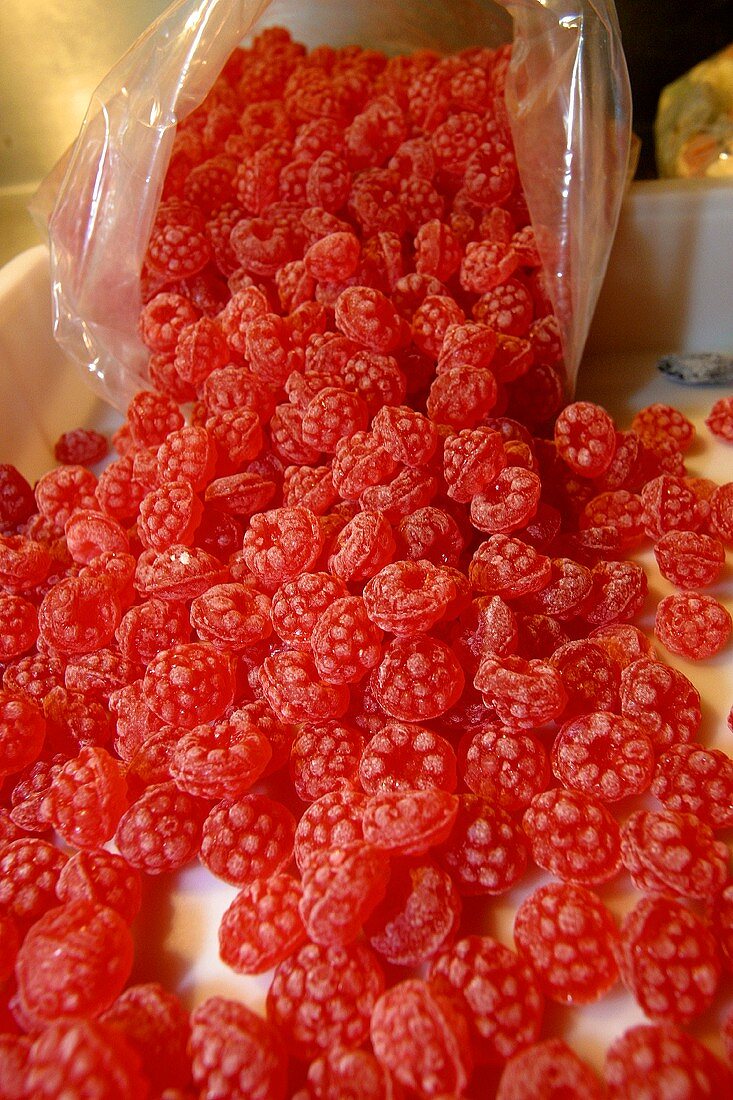 Rote Fruchtbonbons fallen aus Plastiktüte