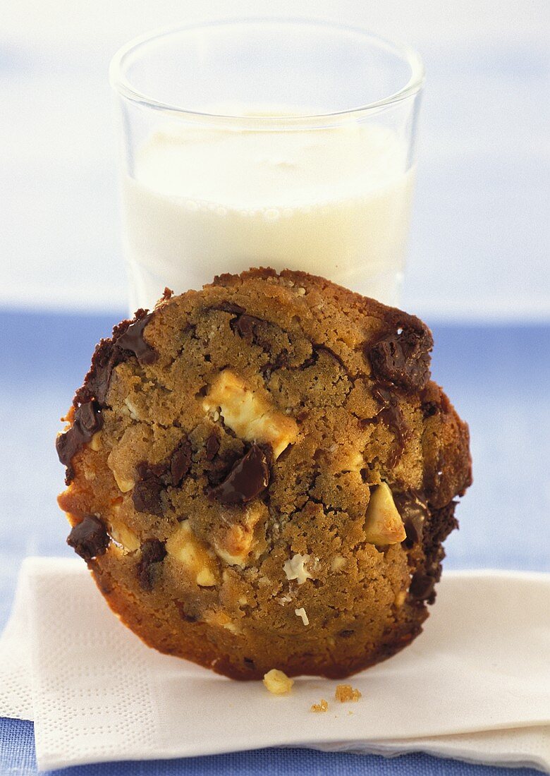 Chocolate chip cookie in front of a glass of milk