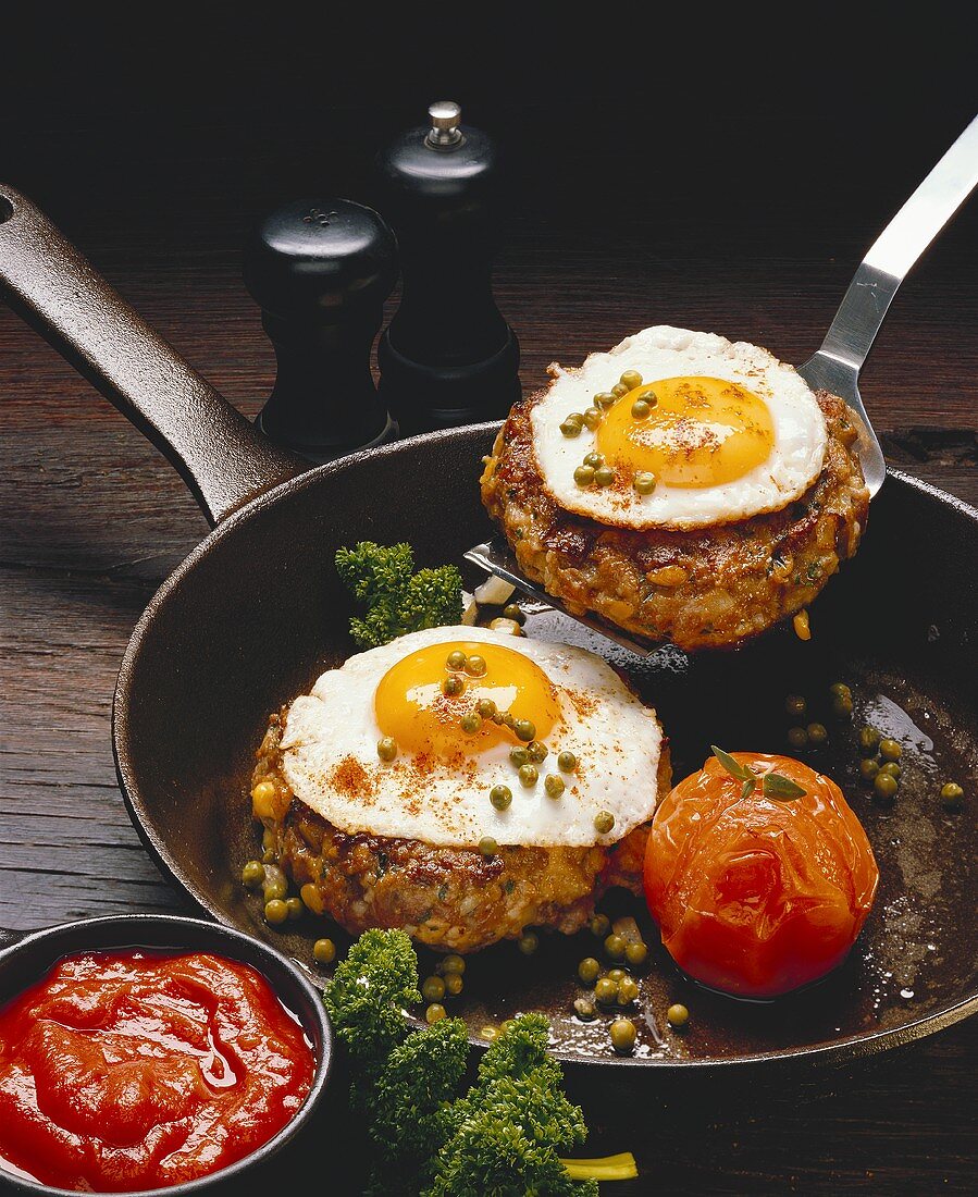 Rissole with fried egg and tomato in frying pan