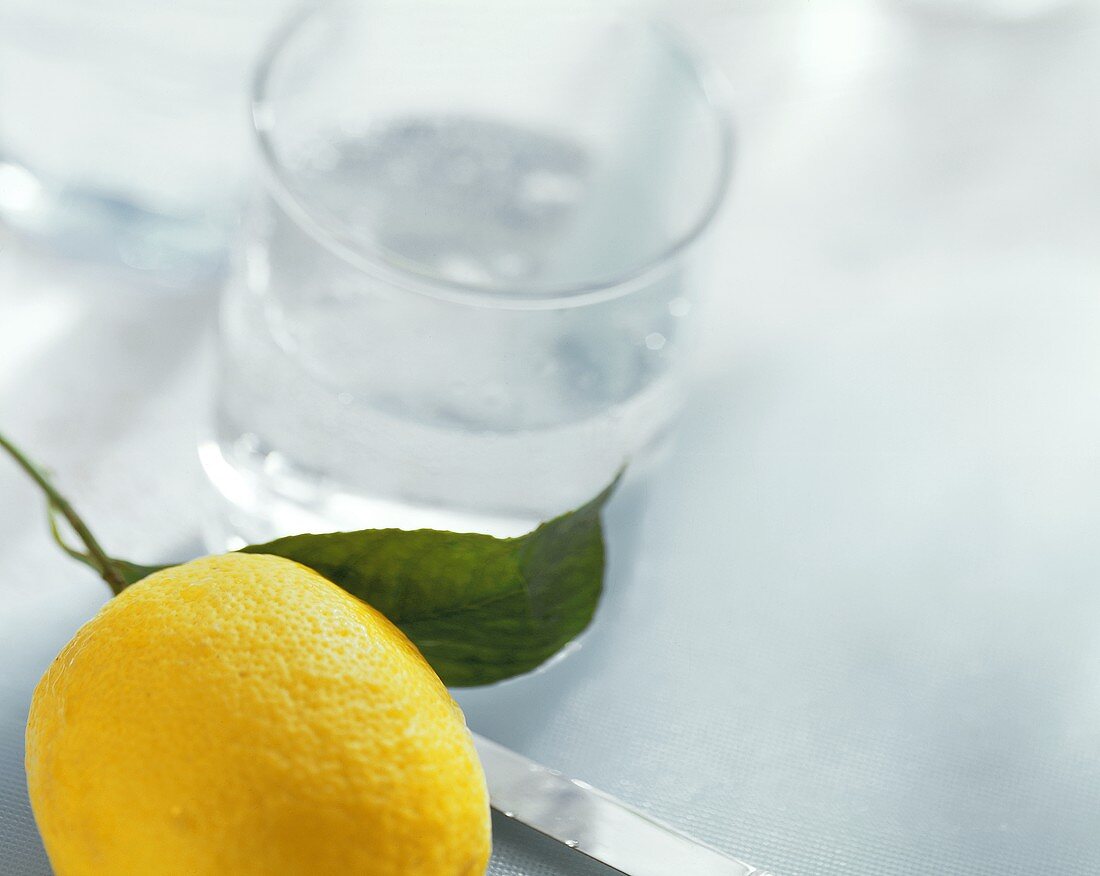 Eine Zitrone und ein Glas Mineralwasser