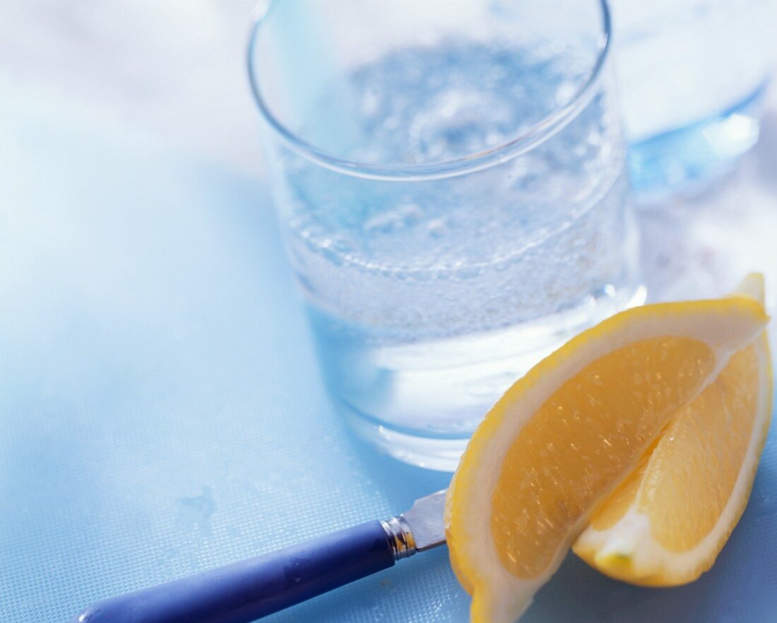 Two lemon wedges and a glass of mineral water