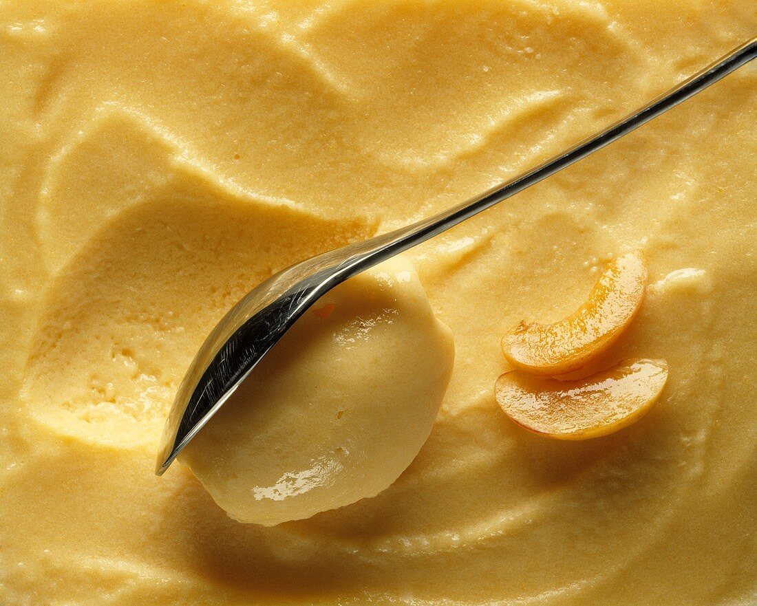 Joghurt-Aprikosen-Eis in flacher Schüssel mit Löffel