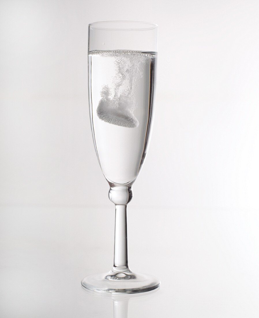 A glass of water with an effervescent tablet