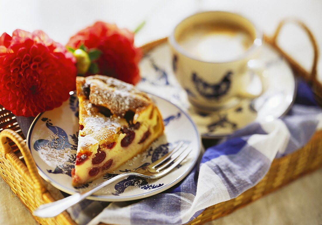A piece of cheesecake with cherries and a cup of coffee