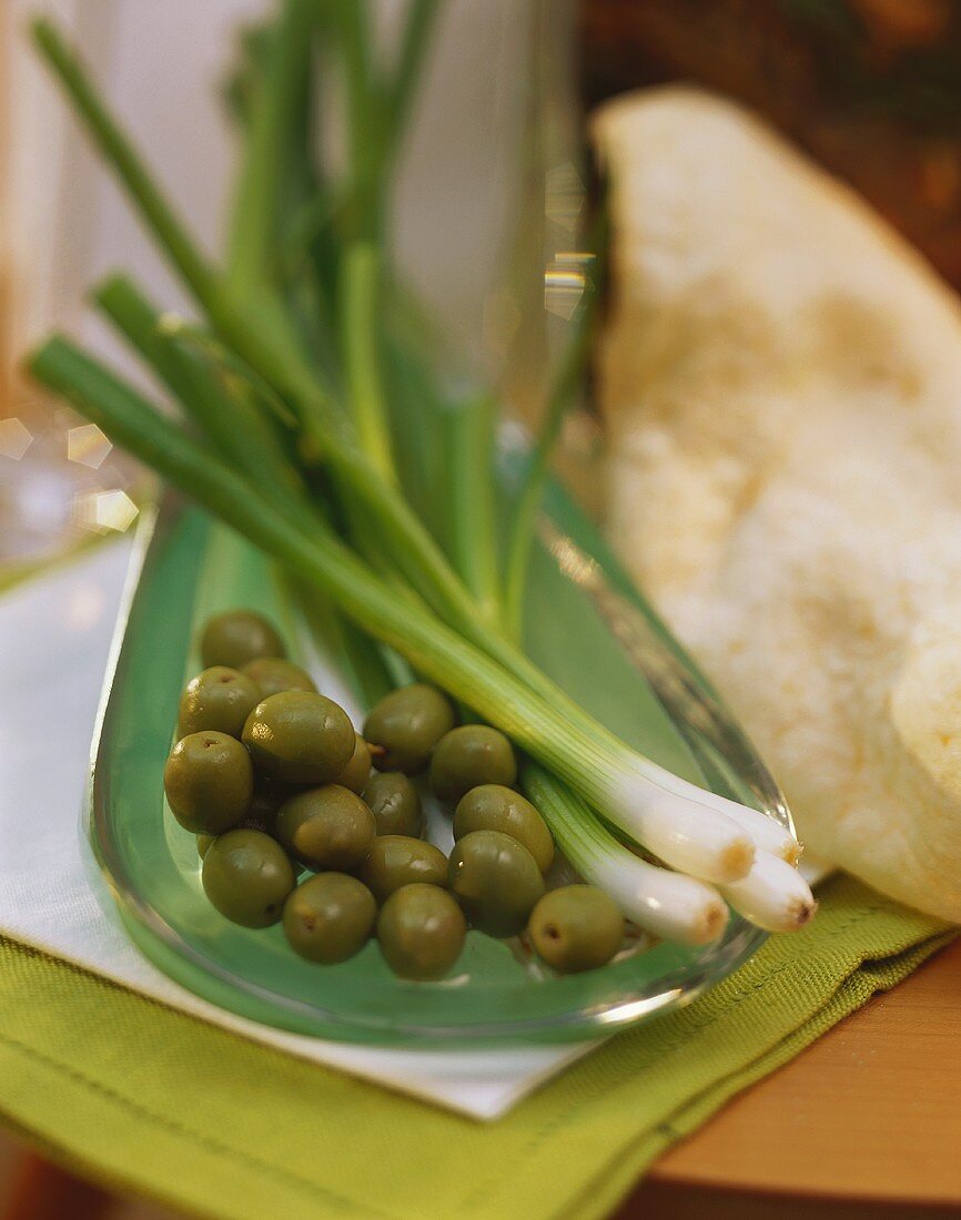 Still life with olives and spring onions