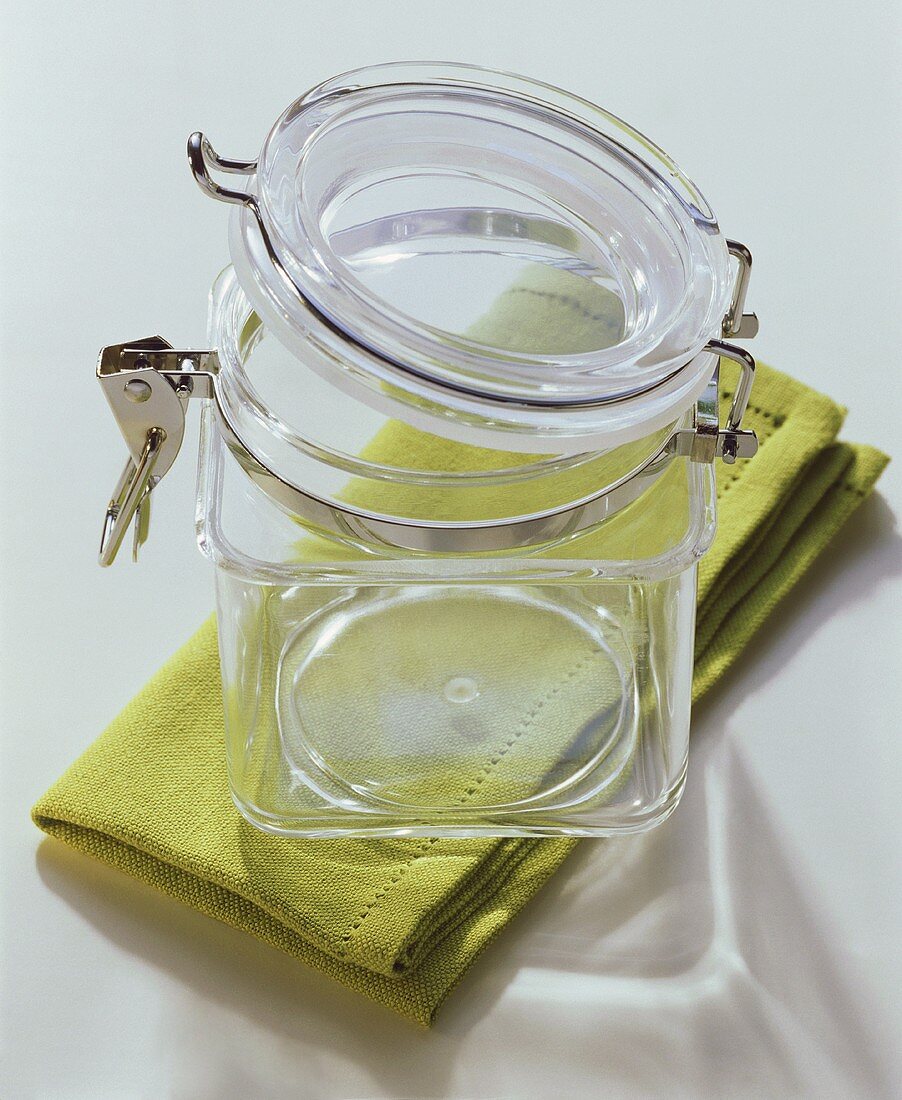 An empty preserving jar on green napkin
