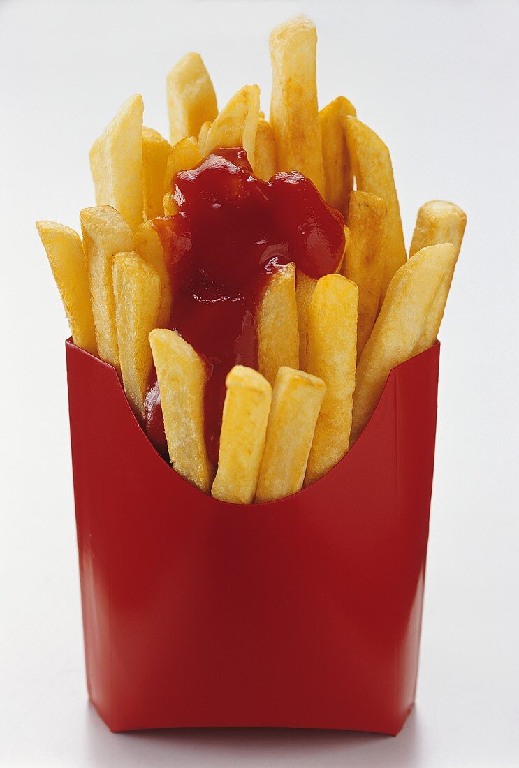 Pommes mit Ketchup in roter Papiertüte